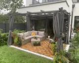 Nowoczesna pergola w ogrodzie z wygodnym narożnikiem i stolikiem. Idealne miejsce na relaks i inspiracje.