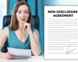 Kobieta w biurze trzyma dokument NDA. Obok niej leży podpisana umowa o poufności.