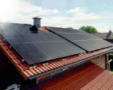 Solceller tillverkning på ett tegeltak. Solen skiner på panelerna som fångar upp energin.