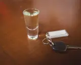 Kieliszek z alkoholem i kluczyki do samochodu. Pamiętaj, że kara za jazdę po pijanemu jest surowa.