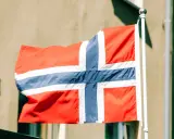 Flaga Norwegii powiewa na wietrze. Myśląc o tym kraju, często zastanawiamy się nad jego gospodarką, czyli **norwegia brutto netto**.