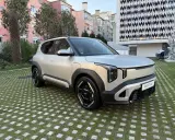 El ev2 kia, un SUV eléctrico plateado, descansa sobre un césped con baldosas cuadradas.