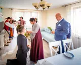 Wzruszający moment błogosławieństwa rodziców. Panna młoda klęczy, a matka z córką udzielają jej błogosławieństwa. W tle gra kapela góralska.