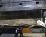 Uszkodzony skraplacz klimatyzacji objawy: zgięte żeberka, widoczne uszkodzenia mechaniczne.