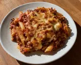 En tallrik med gratinerad pasta med köttfärssås och smält ost. En riktig klassiker som värmer själen.