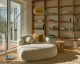 Un accogliente angolo lettura con divanetto curvo, libreria in legno e lampada ad arco. Perfetto per creare le tue idee angolo lettura.