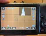 Schermo di una fotocamera **Canon M** in modalità manuale, con istogramma e impostazioni visibili.