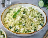 Frischer Couscous Salat mit Feta, Gurken und Minze, garniert mit einer Minzblatt.