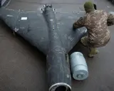 Ein Soldat inspiziert eine Drohne in Rumänien. Daneben liegt eine Munitionshülse.
