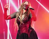 Artist med mask och röda handskar sjunger på scen. Kanske en försmak av Eurovision 2026 tid?