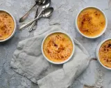Quatre crèmes brûlées dorées, prêtes à être dégustées. La croûte caramélisée de cette crème catalane invite à la gourmandise.