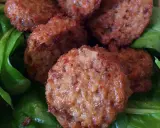 Polpette di lenticchie dorate e croccanti su un letto di spinaci freschi.