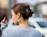 Peinado recogido con trenzas y moños, adornado con un pasador de mariposa. Un look de recogidos sencillos y elegantes.