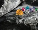 Kolorowe kamienie szlachetne, jakby obietnica zdrowia, lśnią na tle surowej skały.