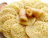 Assiette de crêpes mille trous, garnies de miel et de cacahuètes concassées. Un délice à déguster !