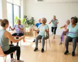 Grupa seniorów ćwiczy z gumami oporowymi, ciesząc się aktywnością w wieku geriatrycznym.