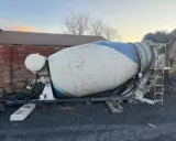 Gruszka betonu, prawdopodobnie o pojemności kilku m3, stoi na placu budowy.