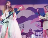 Kvinnlig basist och gitarrist uppträder på en konsert. Bakom dem sitter en trummis. En **first aid kit konsert** kan vara bra att ha nära till hands.