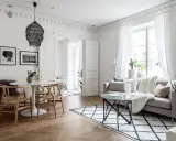 Ljust och luftigt vardagsrum med matbord och inspiration från skandinavisk design. En rund vit matplats med trästolar möter en soffgrupp med mysiga textilier.