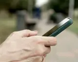 Dłoń trzyma smartfon Huawei, być może przygotowując się do wykonania hard reset.