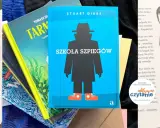 Okładka książki "Szkoła szpiegów" Stuarta Gibbsa, z sylwetką szpiega w kapeluszu i płaszczu. Kolejność książek na zdjęciu sugeruje, że to początek przygody.