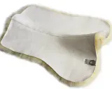 Ein weiches Lammfell, das als Unterlage unter einer Schabracke dient, bietet optimalen Komfort für das Pferd.