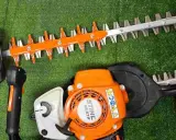 Deux taille-haies Stihl orange et noirs, prêts pour le taillage de haie.