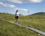 Kvinna vandrar på spång i Gällivare, Sverige. En röd markering syns i bakgrunden.