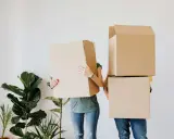 Pareja con cajas de mudanza, como si fueran cabezas, frente a plantas. Cumpliendo con el articulo 22.4 lec.