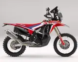 Czerwono-biały motocykl Honda CRF 450 Rally z czarnymi akcentami, gotowy na rajdowe wyzwania.
