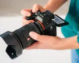 Dłonie trzymają aparat Sony a7r5 z obiektywem 24-70mm.