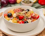 Schüssel mit einem frischen griechischen Kartoffelsalat, garniert mit Oliven, Tomaten, Kapern und Feta.