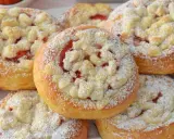 Puszyste drożdżówki z truskawkami, posypane cukrem pudrem i kruszonką. Idealne na letnie popołudnie.