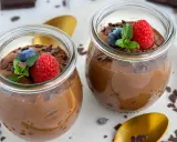 Zwei Gläser mit luftiger Schokomousse, garniert mit frischen Beeren und Schokostückchen. Ein Genuss für Schokoladenliebhaber!