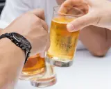 Dwie osoby wznoszą toast piwem. Pytanie: czy chory na raka może pić alkohol?