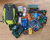 Plecak, kijki trekkingowe, bukłak, kurtka i inne akcesoria gotowe na wyjazd w góry.