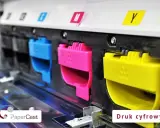 Kolorowe wkłady drukujące (cyjan, magenta, żółty) w drukarce, symbolizujące nowoczesne technologie druku.