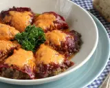 Pimientos rellenos de carne cubiertos con una cremosa salsa, decorados con perejil fresco.