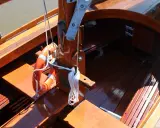 Le bois de bateau verni brille au soleil. Une bouée orange est accrochée, prête pour l'aventure.