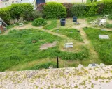 Un jardin envahi par l'herbe haute, prêt à être entretenu. Il faudra bientôt tondre la pelouse pour redonner une belle apparence à cet espace extérieur.