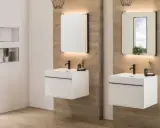 Modernos lavabos blancos flotantes con grifería negra, espejos iluminados y detalles en madera. ¡Ideas para baños elegantes!
