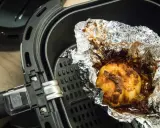 Ein gebackener Knoblauch in Alufolie in einem Airfryer. Ist Airfryer gesund? Ja, mit wenig Öl.