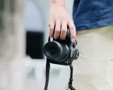 Dłoń trzyma aparat Canon EOS R7, gotowy do uchwycenia chwili. Jego matryca w aparacie zapewni doskonałą jakość zdjęć.