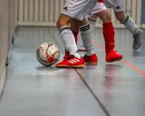 Piłka do futsalu na hali, obok butów zawodników. Tak, w turfy można grać na hali, to właśnie futsal!