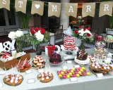 Una encantadora mesa dulce boda con pasteles, cupcakes, macarons y flores.