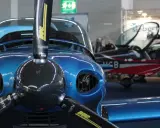 Glänzende blaue Flugzeugfront mit Propeller, im Hintergrund ein rotes Flugzeug. Ein Blickfang für jedes flieger magazin.