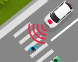 Coche eléctrico blanco se acerca a un paso de peatones. El sonido de los coches eléctricos es casi inaudible, pero las ondas rojas indican que detecta a los peatones.