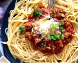 Spaghetti bolognese, prosty przepis. Aromatyczny sos mięsny z mielonym mięsem i pomidorami na złocistym makaronie, posypany serem i natką pietruszki.