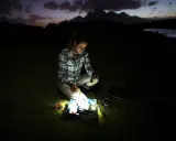 Kobieta przygotowuje się do nocnego łowienia. Czy 800 lumenów to dużo, by zobaczyć przynęty w ciemności?