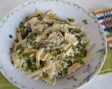 Pyszny makaron farfalle z tuńczykiem i szpinakiem, posypany świeżą natką pietruszki. Idealny na szybki obiad.